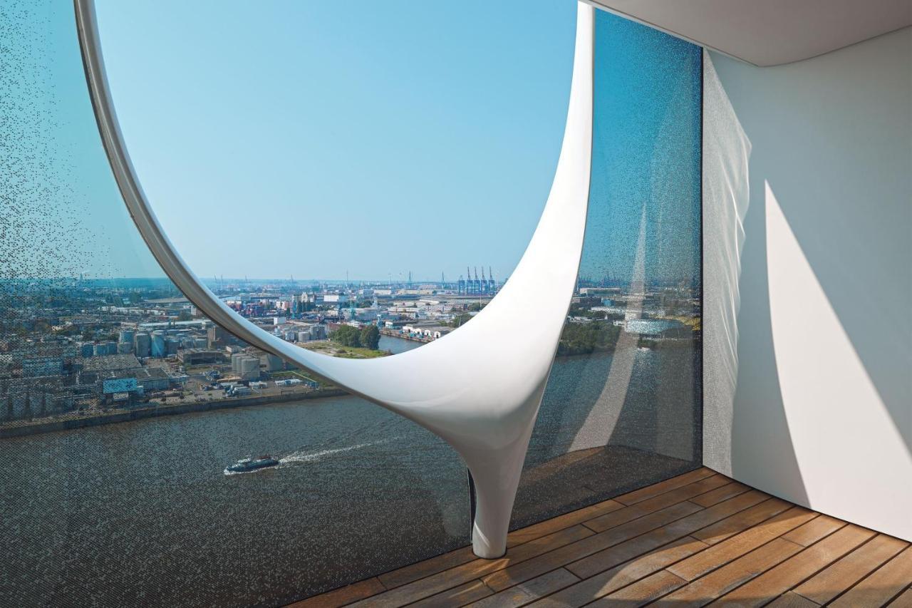 Hotel The Westin Hamburg Elbphilharmonie Exterior foto The photo showcases a modern architectural interior featuring a large, uniquely designed window that creates a dramatic visual effect. The window has an organic, flowing shape, resembling a sculptural element, and is made of glass that allows natural