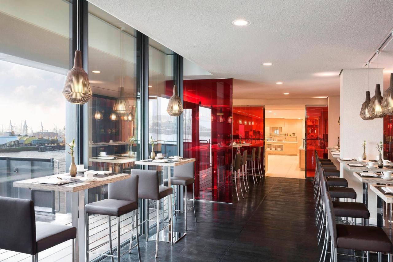 Hotel The Westin Hamburg Elbphilharmonie Exterior foto The photo showcases a modern restaurant interior characterized by sleek design and contemporary decor. The space features a combination of large windows allowing natural light to filter in, creating an open and airy atmosphere. The walls are accented
