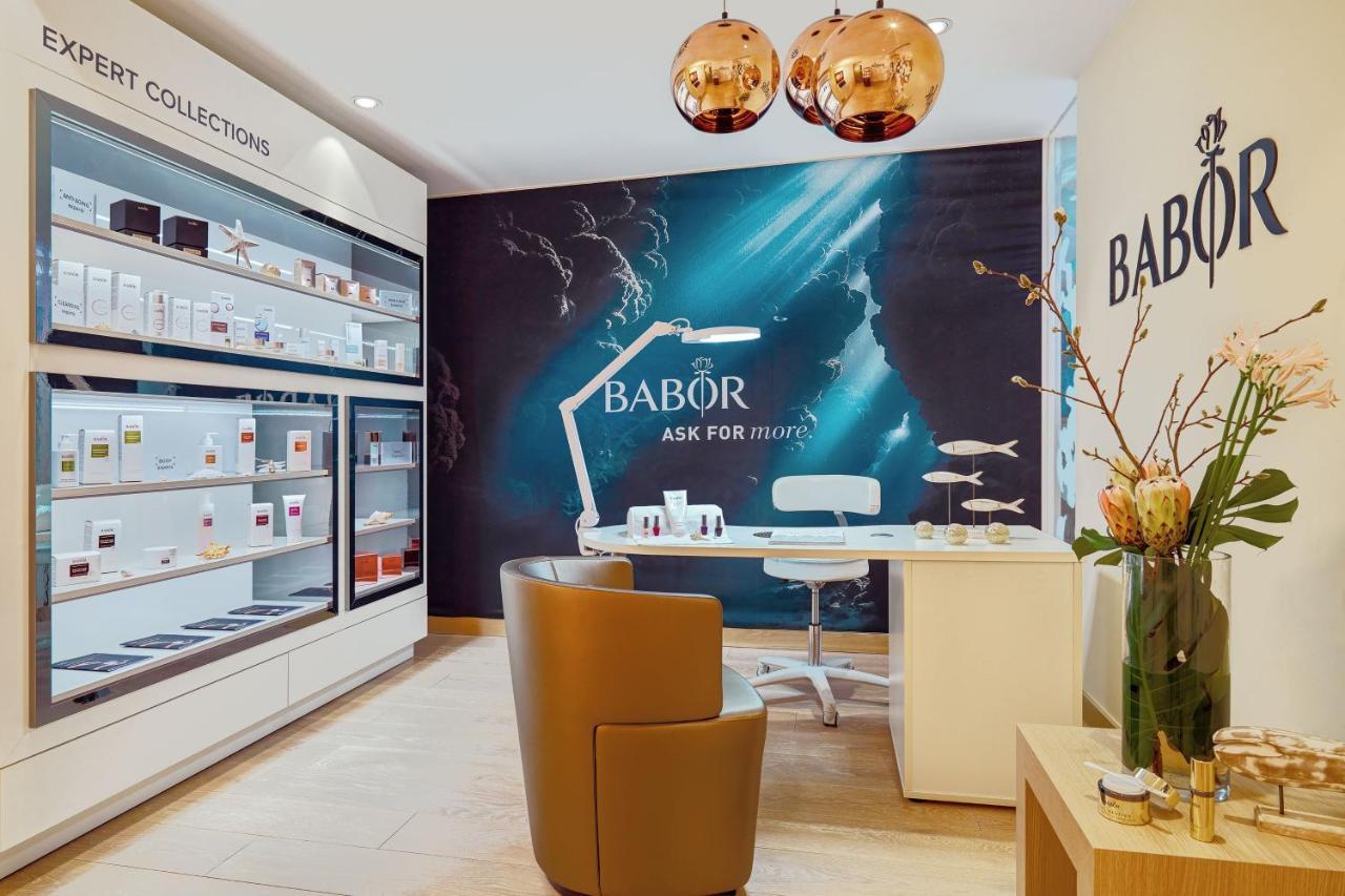 Hotel The Westin Hamburg Elbphilharmonie Exterior foto The image shows an interior shot of a beauty salon or spa that features products from the brand Babor. The space includes a stylish brown chair, a modern white desk, and a decorative display of skincare products on shelves. There is also a prominent 